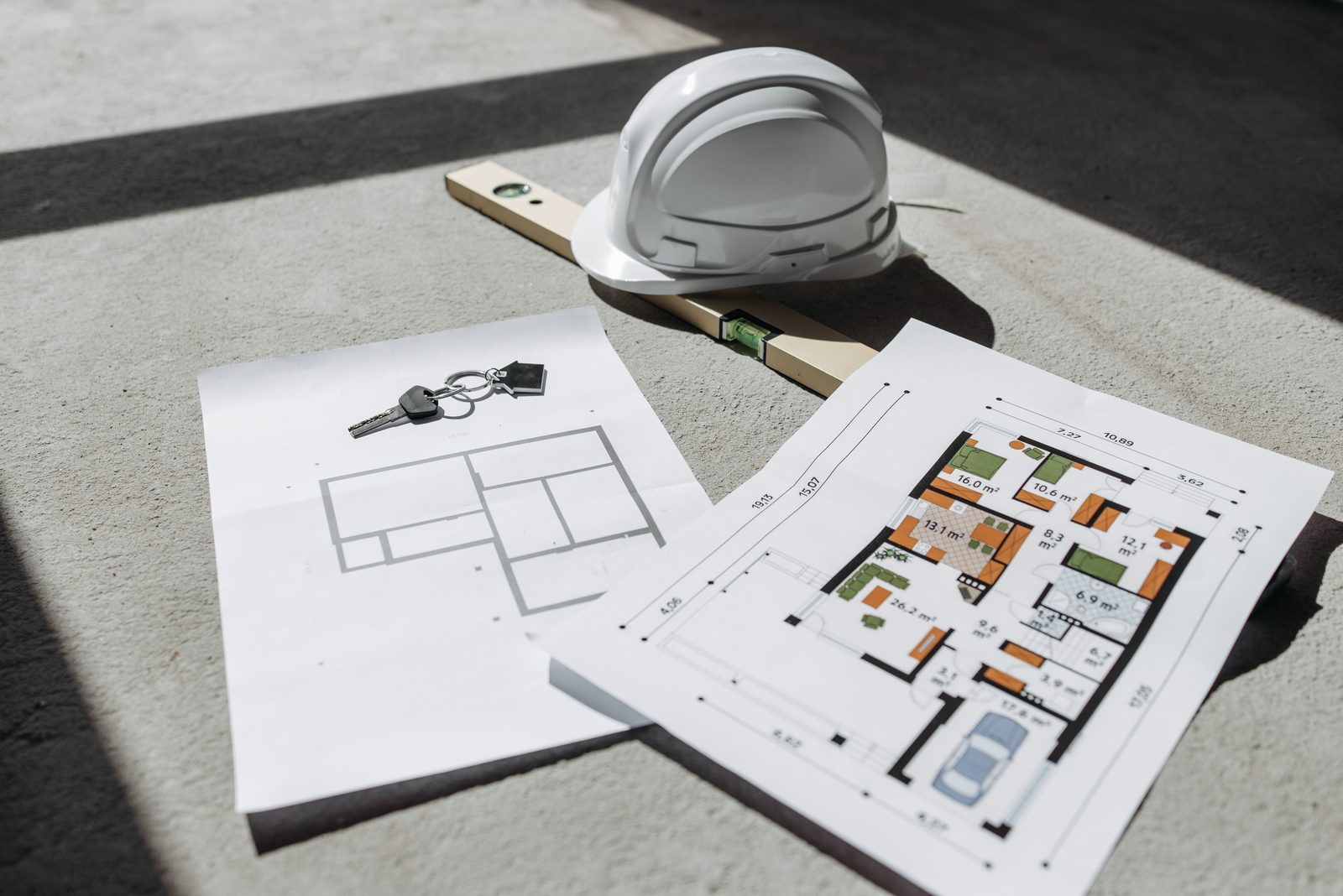 Planos de vivienda con casco de obra y llaves